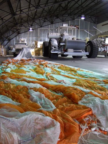 A parachute laid out in front of one of the balloon launch vehicles.
